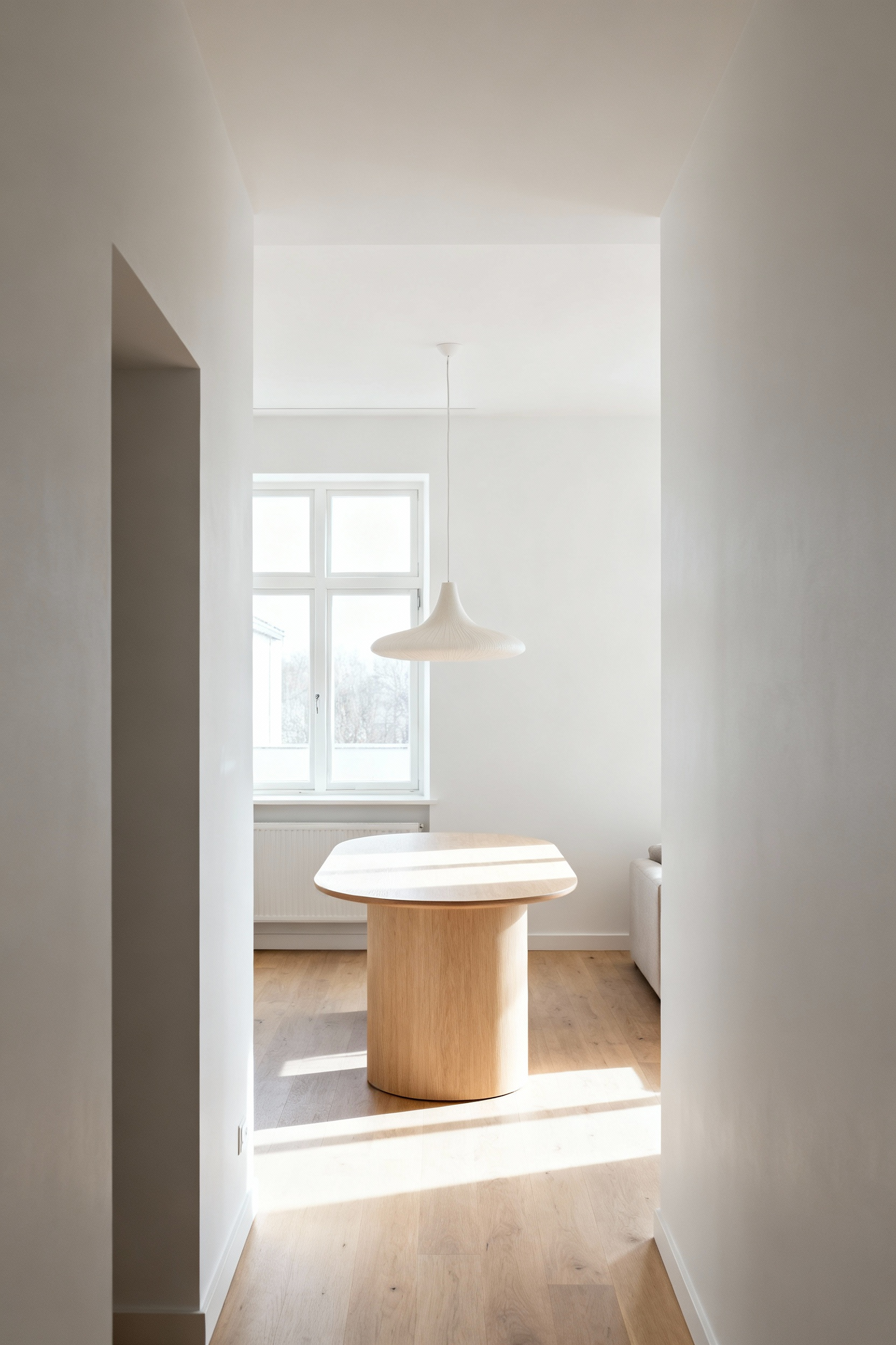 Minimalist Nordic dining room showcasing thoughtful visual corridors and seamless flow, with a modern wooden table, large window, continuous flooring, and soft lighting.